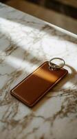 leather keychain resting on marble table with sunlight casting shadows photo