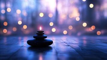burning candle balancing on stack of zen stones in a blurred background representing serenity photo