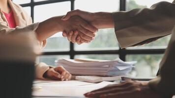 Two business people shaking hands over paperwork video