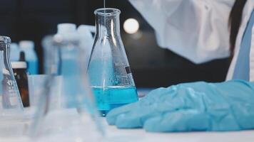 A person in a lab coat is holding a test tube video