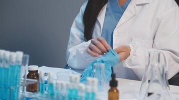 A woman in a lab coat is working on a test tube video