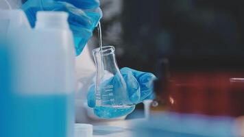 A person in a lab coat is holding a test tube video