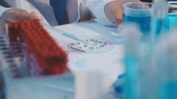 A person in a lab coat is working on a test tube video