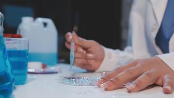 A person in a lab coat is working on a test tube video
