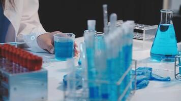 A person in a lab coat is working on a blue liquid video