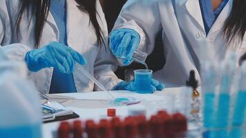 Two women in lab coats and gloves are working on a project video