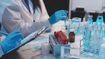 Two people in lab coats are working on a clipboard video