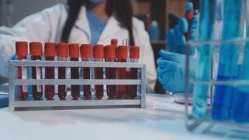 A woman in a lab coat is holding a test tube video
