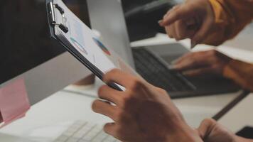 A person is holding a clipboard while another person is using a computer video