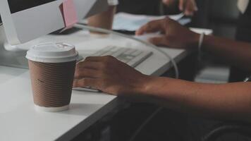 A person typing on a computer with a cup of coffee video