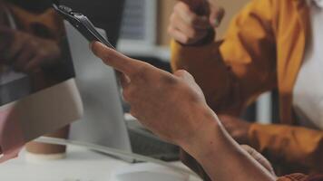 A person holding a cell phone while sitting at a desk video