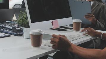 A person sitting at a desk with a laptop and coffee video