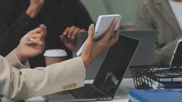 A group of people sitting at a table with laptops video