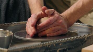 Master man craftsman kneading crumpling holding piece of clay hands potter pottery sculpting workshop artisan preparing raw material for making earthenware handmade shaping craft male working studio video