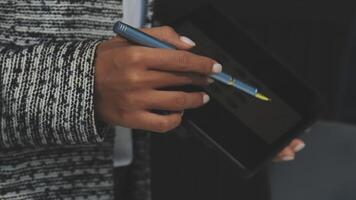 A person holding a pen and tablet in front of them video