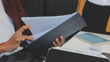 A man is holding a folder while sitting at a desk video