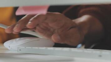 A person's hand is holding a sticky note on a computer keyboard video