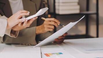 Two people are working on paperwork at a desk video