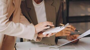 Two people are working on paperwork at a desk video