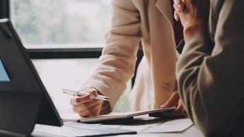 Two people working on a laptop in front of a window video