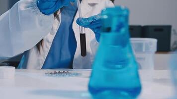 uma mulher dentro uma laboratório casaco é segurando uma teste tubo video