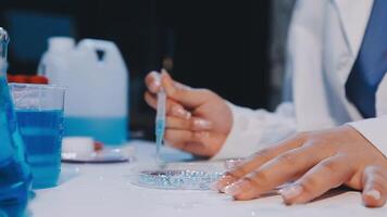 A person in a lab coat is working on a test tube video