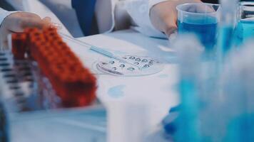 A person in a lab coat is working on a test tube video