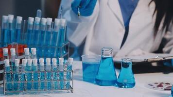A woman in lab coat is working on a test tube video