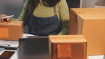 A woman is working on a laptop while holding a pen video