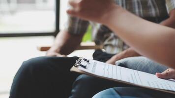 A person is holding a clipboard while sitting on a couch video