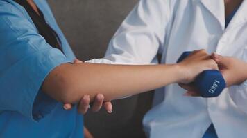 A doctor is holding a dumbbell while another person is holding it video