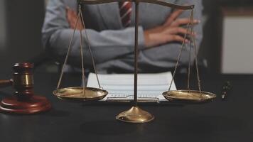 A lawyer holding a scale of justice in front of a desk video