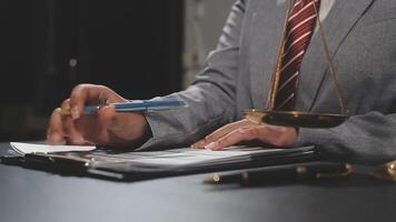 A man in a suit is writing on a piece of paper video
