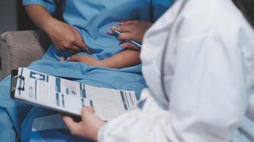 A doctor is holding a clipboard while a patient is sitting on a chair video