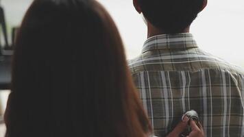 A man and woman are standing in front of a window video