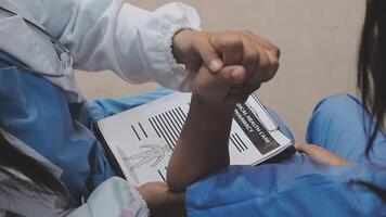 A doctor is holding a patient's hand while they are sitting on a chair video