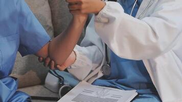 Two nurses are holding hands while sitting on a couch video