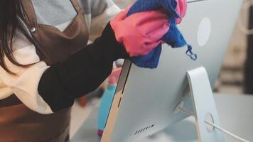 A woman in an apron is cleaning a computer video