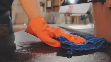 A person cleaning a table with a blue cloth video
