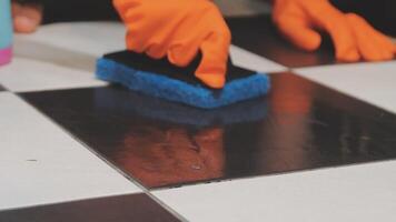 A person cleaning a black and white tile with a sponge video