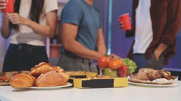 A group of people standing around a table with food video