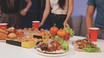 A group of people standing around a table with food video
