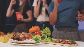 A group of people standing around a table with food video