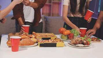 A group of people standing around a table with food video