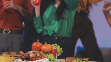 A group of people standing around a table with food video