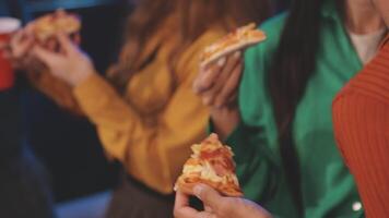 A group of people holding slices of pizza video