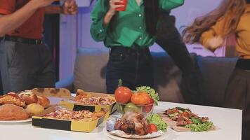 A group of people standing around a table with food video