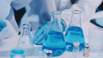 A person in a lab coat is holding a test tube video