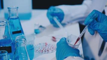 A person in a lab coat is holding a test tube video