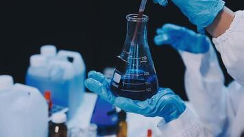 A person in a lab coat holding a test tube video